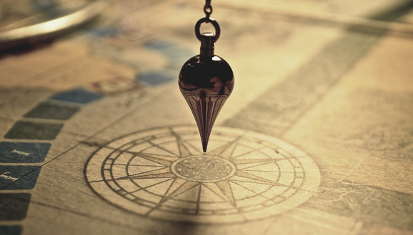 A pendulum pointing to a drawn compass